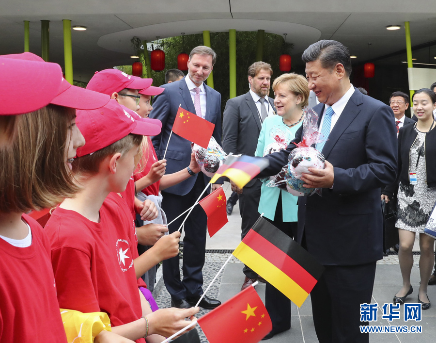 7月5日，国家主席习近平同德国总理默克尔共同出席柏林动物园大熊猫馆开馆仪式。这是习近平向现场的孩子们赠送大熊猫毛绒玩具。 新华社记者谢环驰 摄