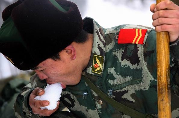 2008年2月3日，一名武警戰士在京珠高速公路破冰鏟雪間隙吃雪解渴。（來源：新華社）