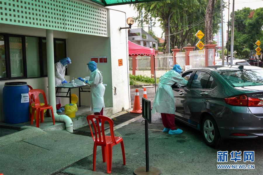 3月30日,在马来西亚吉隆坡附近,医护人员在一处新冠肺炎检测点为