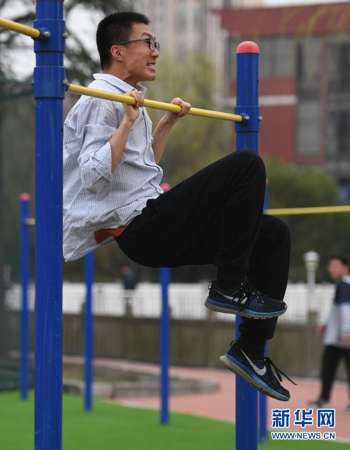 3月10日,在江苏省锡山高级中学,学生在做引体向上.
