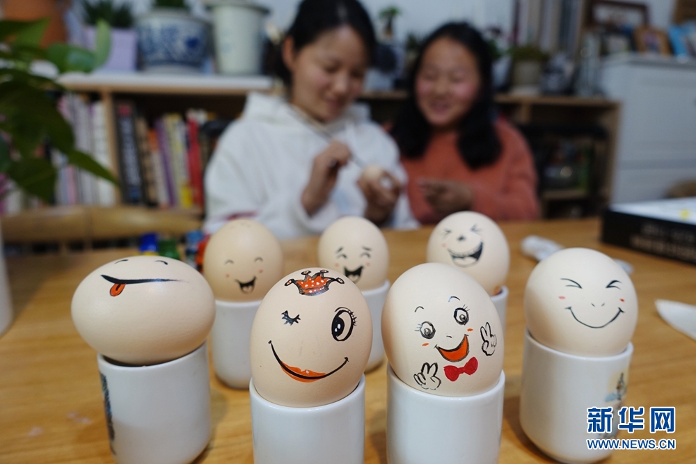 4月2日,李娜在鸡蛋上创作的绘画"笑脸一家亲".