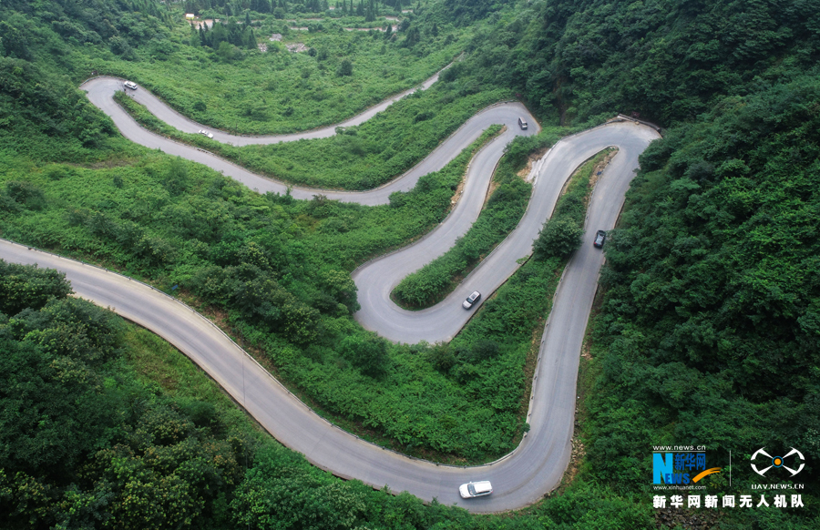 图为汽车在蜿蜒而上的乡村公路上行驶.青山秀丽,山路弯弯.