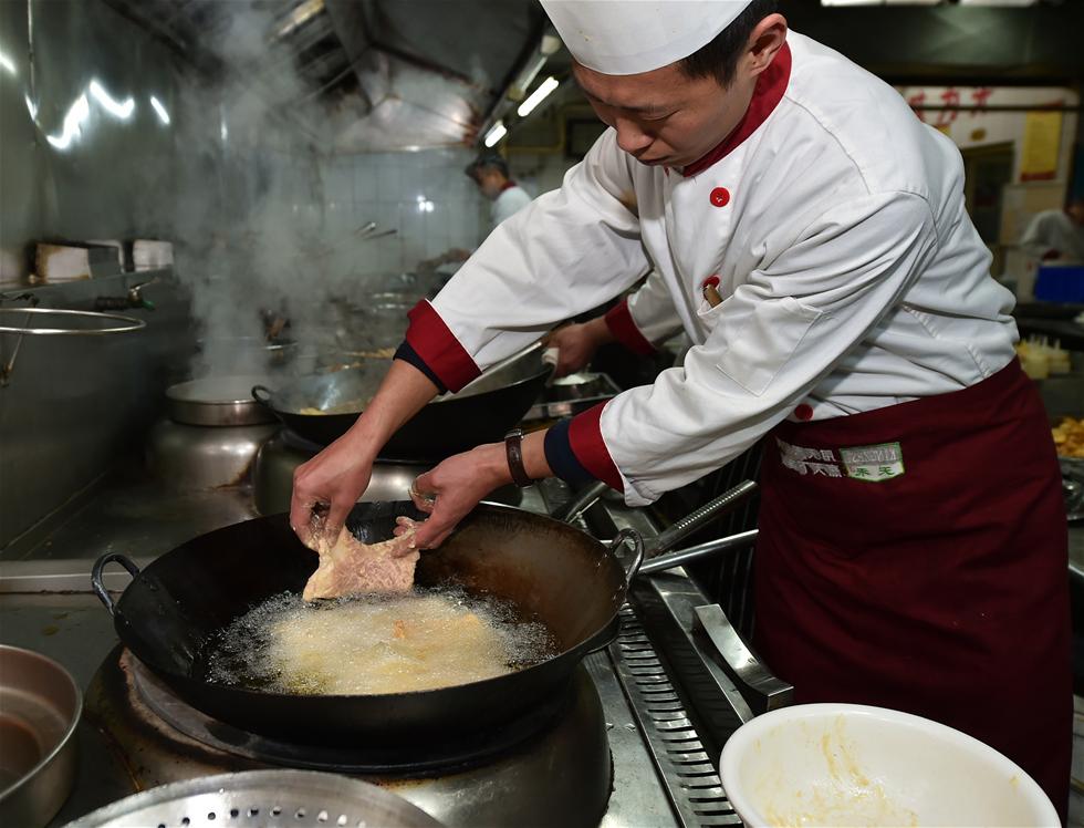 1月11日,汾阳丰泰苑酒店厨师长孙晋咏在炸制酥肉.