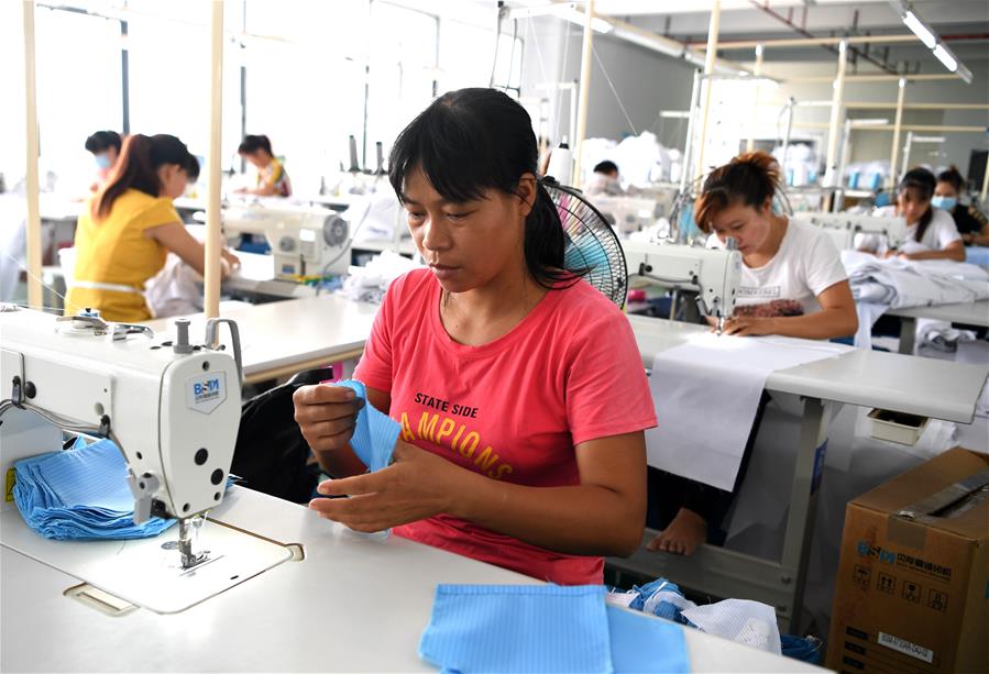 9月7日,工人在宁明县一家服装加工厂的扶贫车间缝制衣服.