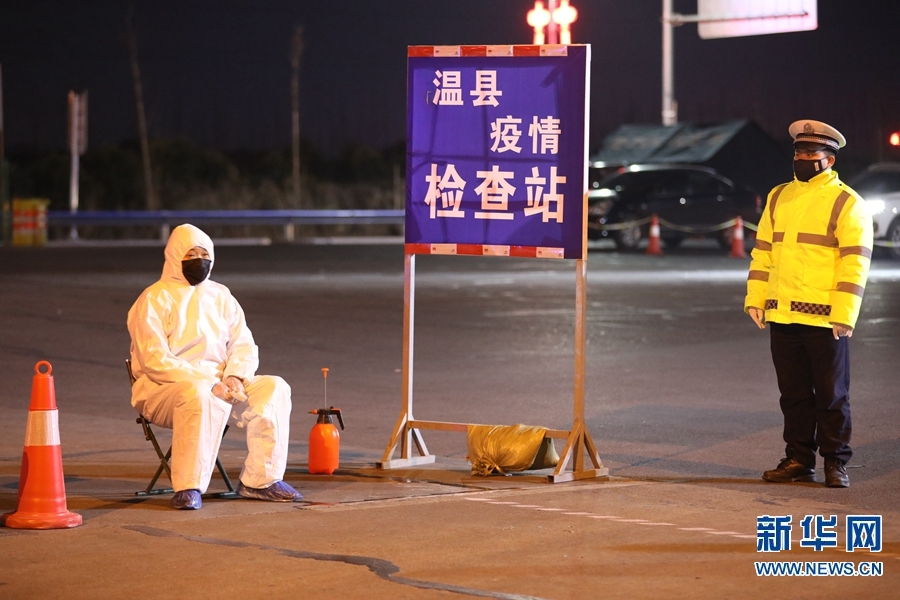 2月2日晚,在河南省温县焦温高速口疫情防控检测站,工作人员为过往