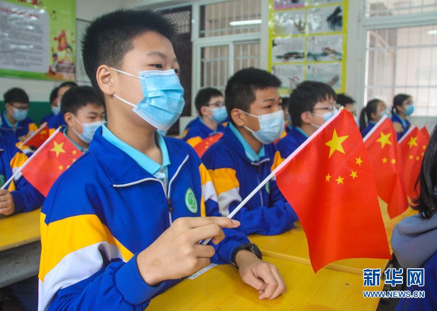 9月7日,河南省南阳市第三中学解放路校区教室,学生们手拿国旗在认真