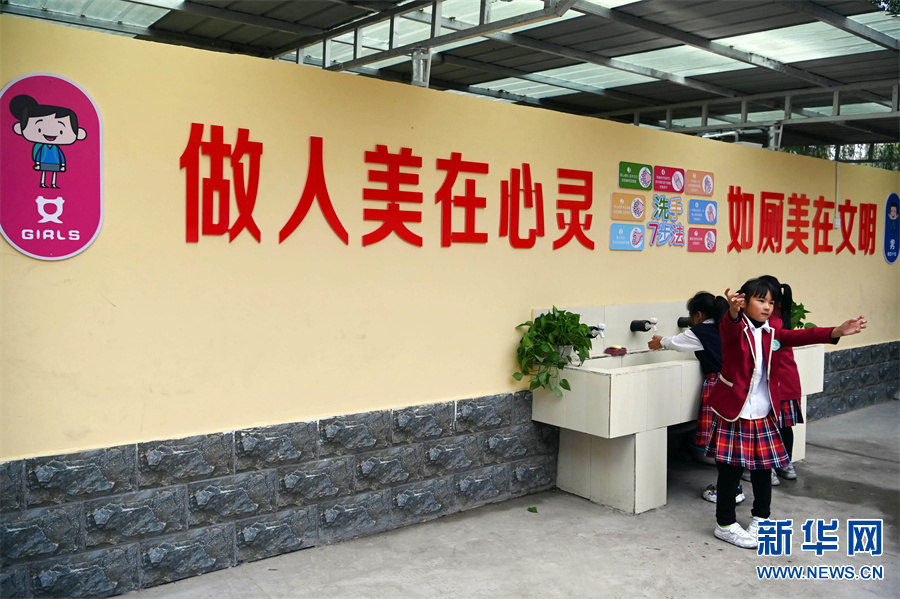 10月12日,河南省焦作市沁阳市第三小学,一名学生在厕所文化墙下摆