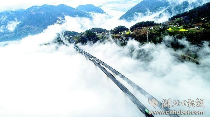 这五年，是中国高速公路与高铁发展最快的五年，也是湖北之路全力提速冲刺的五年。长龙飞跃，流光溢彩，关山万里，御风而行。“铁水公空”的立体交通优势，为现代化的快速集散和高效流通提供了最强有力的支撑。图为：沪渝高速公路横贯鄂西，翻山越岭，穿云破雾。