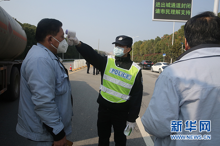 图为武汉公安民警检测司乘人员体温