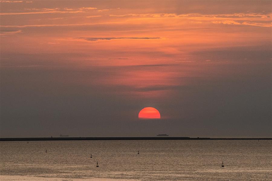 落日余晖映海口