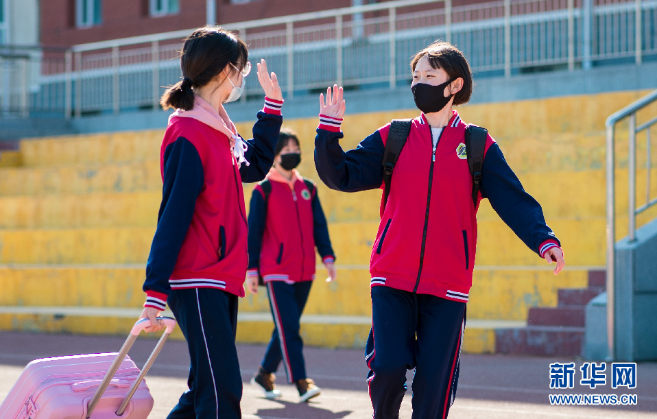 4月26日,呼和浩特市第十二中学复课,久违的同学见面后开心击掌.