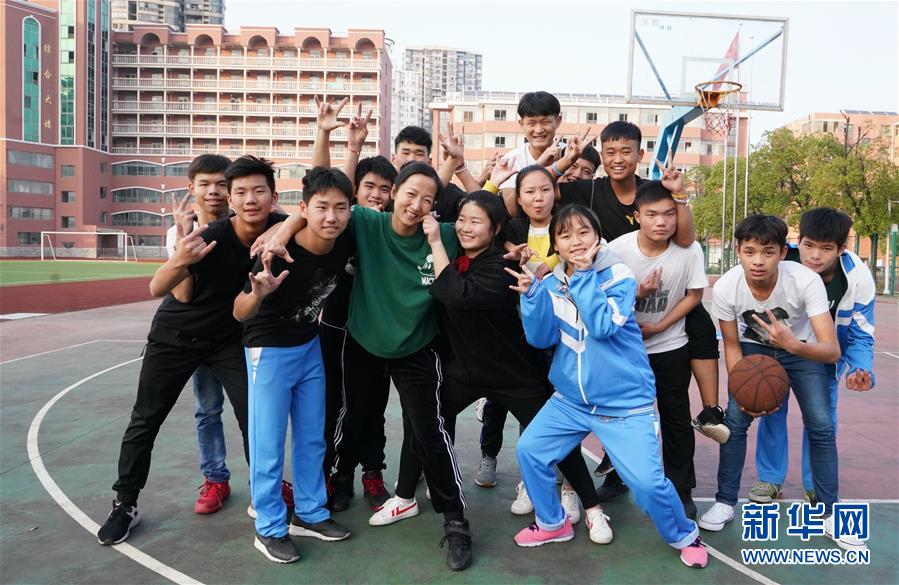 11月26日,曾文萍(前排绿衣者)和学校篮球队的部分成员在学校操场