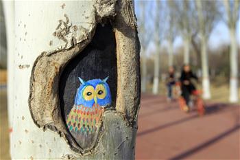 手绘“树洞画”添彩公园